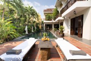 ein Pool in der Mitte eines Gebäudes mit einem Resort in der Unterkunft Trúc Huy Tranquil Villa in Hoi An