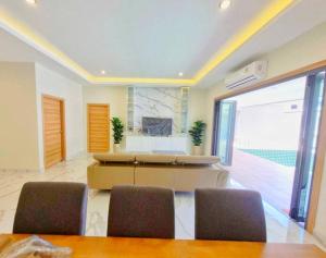 a living room with a table and some chairs at Pool Villa Rawai in Ban Saiyuan (1)