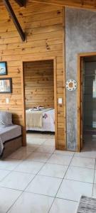 um quarto com uma cama numa parede de madeira em Moradas do Maneca em Imbituba