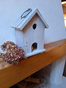 una casa de aves sentada en una cornisa de madera en Haus Rieder, en Pfarrwerfen