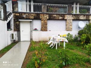 a table and chairs in a yard next to a building at Swimming and Sun in Gandosso