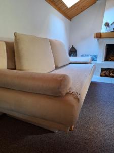 ein braunes Sofa in einem Zimmer mit Kamin in der Unterkunft Haus Rieder in Pfarrwerfen