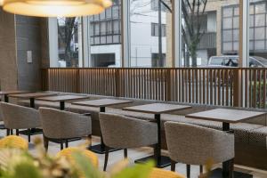 a row of tables and chairs in a restaurant at しまなみプライムホテル今治 in Imabari