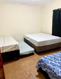two twin beds in a room with at Casa amarela in Juiz de Fora