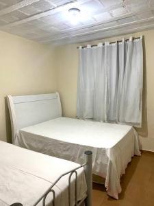 a hospital room with two beds and a window at Casa amarela in Juiz de Fora