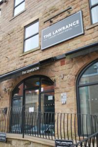 a brick building with a sign for the lawrance at The Lawrance Luxury Aparthotel - Harrogate in Harrogate