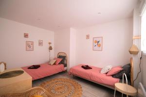 duas camas num quarto com lençóis vermelhos e uma mesa em Dewailly, 3 couchages, élégant, proche centre ville em Amiens
