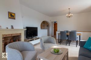 ein Wohnzimmer mit Kamin und ein Esszimmer in der Unterkunft Villa Sunset Rock by Abahana Villas in Benitatxell