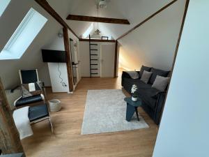 a living room with a black couch and a chair at City-Apartment in bester Lage in Münster