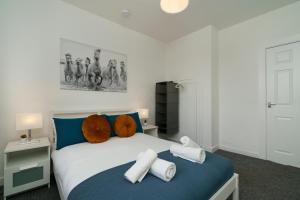 ein Schlafzimmer mit einem blauen und weißen Bett mit Handtüchern darauf in der Unterkunft Free Parking - 2 Bedroom Flat in Cambusnethan