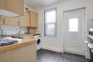 a kitchen with a sink and a washing machine at Wimbourne Road Apartment 3 in Bournemouth
