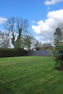 a large grassy yard with a fence and trees at The Lawrance Luxury Aparthotel - Harrogate in Harrogate