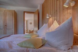 een slaapkamer met een groot wit bed met kussens bij Ferienwohnungen Mayr in Bad Wiessee