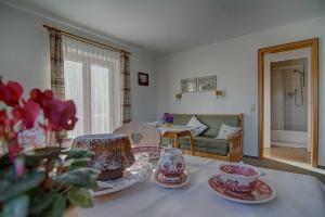 een woonkamer met een tafel met borden erop bij Ferienwohnungen Mayr in Bad Wiessee