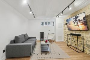 een woonkamer met een bank en een tafel bij KAZA BELLA - Maisons Alfort 5 Luxurious apartment with private garden and Jacuzzi in Maisons-Alfort