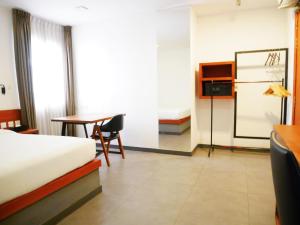 a bedroom with a bed and a desk and a table at Cheers Social Apartment & Hotel in Phnom Penh +7 photos