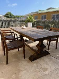 uma mesa de madeira com duas cadeiras e um banco de madeira em Casita de Rincon 1 em Hato