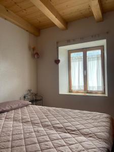 - une chambre avec un grand lit et une fenêtre dans l'établissement Chalet Maso del Bepo, à Canal San Bovo