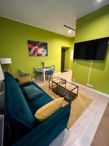uma sala de estar com um sofá azul e uma televisão de ecrã plano em Apartment Targowa L7 em Lublin