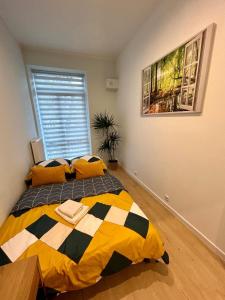 1 dormitorio con 1 cama con almohadas amarillas y negras en Apartment Targowa L7 en Lublin