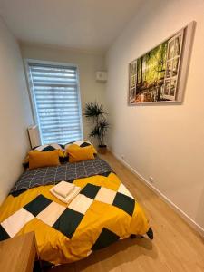 a bedroom with a bed with yellow and black pillows at Apartment Targowa L7 in Lublin