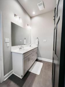 a bathroom with a sink and a large mirror at New Luxury Townhome in Youngsville