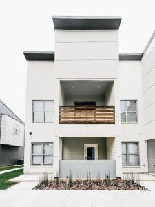 a white building with a balcony on it at New Luxury Townhome in Youngsville