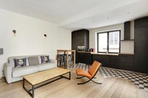 a living room with a couch and a table at Pick A Flat's Apartment in Le Marais - Rue Sainte Croix de la Bretonnerie in Paris