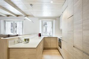 a kitchen with white counters and wooden cabinets at Luderna - Apartamento con terraza Val de Ruda A28 les Ours Polaires in Baqueira-Beret
