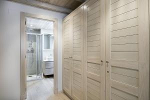 a bathroom with wooden closet doors and a sink at Luderna - Apartamento con terraza Val de Ruda A28 les Ours Polaires in Baqueira-Beret +10 photos