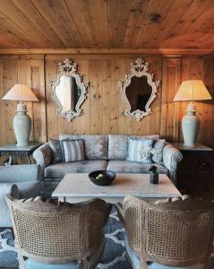 a living room with a couch and a table and mirrors at LeCrans in Crans-Montana