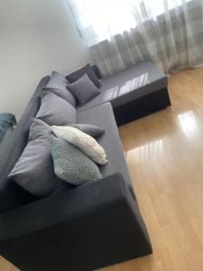 un sofá negro con almohadas en la sala de estar en Schönes Studio im Herzen von Homburg, en Homburg