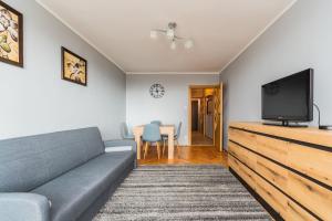 a living room with a couch and a flat screen tv at Fala 2 by Grand Apartments in Gdańsk