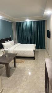 ein großes Schlafzimmer mit einem Bett und einem Tisch in der Unterkunft Vell Grey Hotel in Martuni
