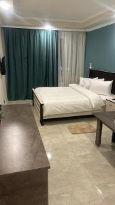 Martuni的住宿－Vell Grey Hotel，一间卧室配有一张大床和一张桌子
