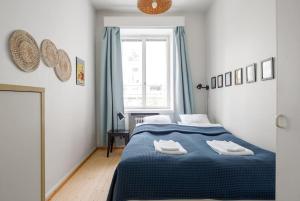 Un dormitorio con una cama azul y una ventana en WeHost Spacious 2BR in the Helsinki Center en Helsinki