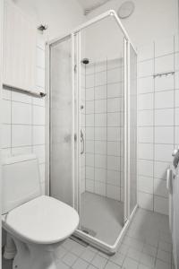 y baño blanco con ducha y aseo. en WeHost Spacious 2BR in the Helsinki Center en Helsinki