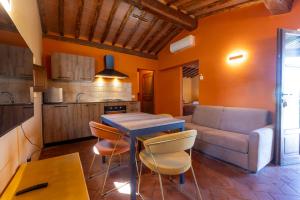eine Küche und ein Wohnzimmer mit einem Tisch und einem Sofa in der Unterkunft Podere Sant'Antonio in Asciano