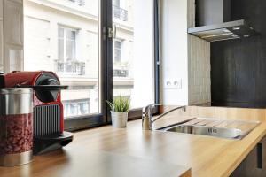 a kitchen with a sink and a window at Pick A Flat's Apartment in Le Marais - Rue Sainte Croix de la Bretonnerie in Paris