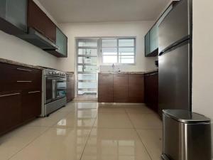 a large kitchen with wooden cabinets and stainless steel appliances at Departamento Torres Mina Residencial in Villahermosa