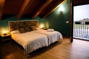 1 dormitorio con cama grande y ventana grande en As Fuebas de Patricio, en Vío