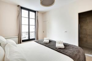 a bedroom with a large bed with towels on it at Pick A Flat's Apartment in Le Marais - Rue Sainte Croix de la Bretonnerie in Paris