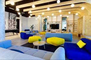 sala de estar con sofás azules y amarillos y TV en Sweetly I-Art, en Gradignan