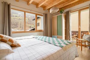 una camera da letto con un letto grande e una grande finestra di SoHome Le Chable a Le Châble