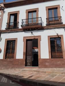 a white building with windows and a door at Apartamento Centro in Montoro +5 photos