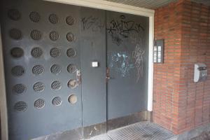 una porta di metallo con graffiti sul lato di un edificio di (id038) Gormsgade 96 3 sal dør 13 a Esbjerg