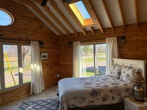 1 dormitorio con 1 cama en una habitación con ventanas en Light House, en Brackley Beach