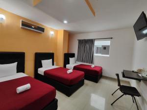 a hotel room with two beds and a desk at HOTEL MILLA SUITES MERIDA in Mérida