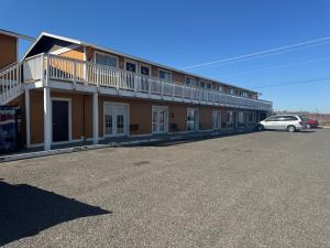 a building with a car parked in a parking lot at Airport Motel in Pasco