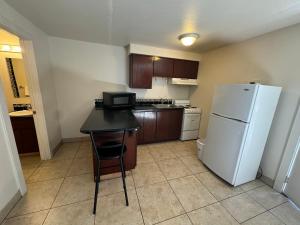 a kitchen with a white refrigerator and a table at Airport Motel in Pasco